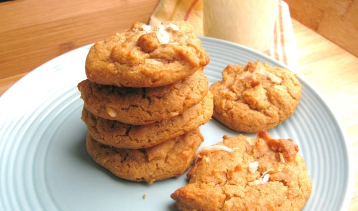 A plate of coconut peanut butter cookies with a glass of milk.