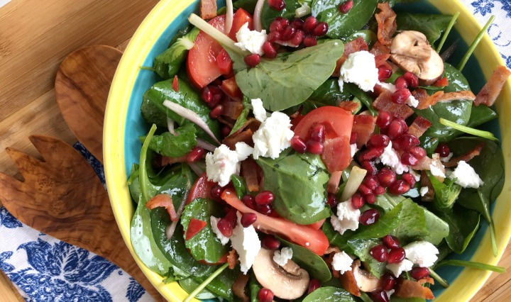 Brightly colored spinach salad with pomegranate