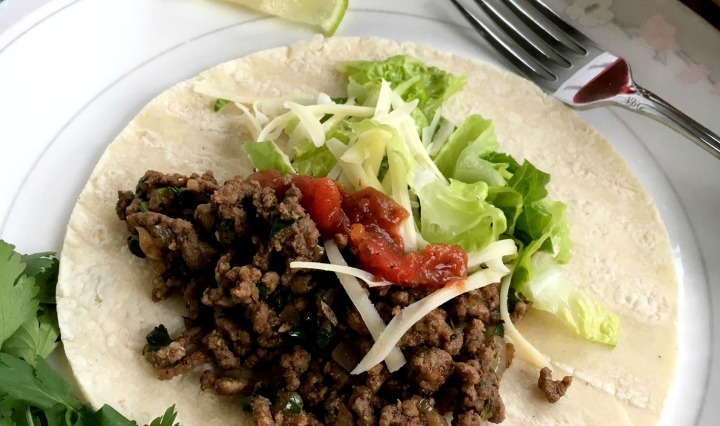 Ground beef taco meat on a flour tortilla