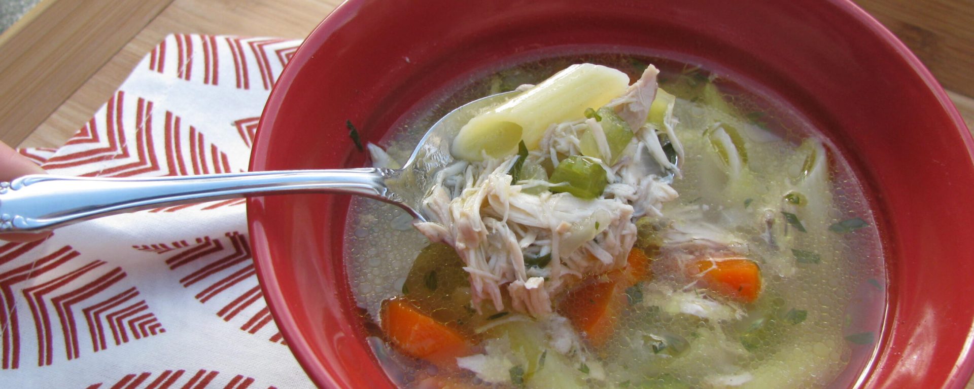 Shredded chicken and vegetables in this bowl of rainy day chicken soup